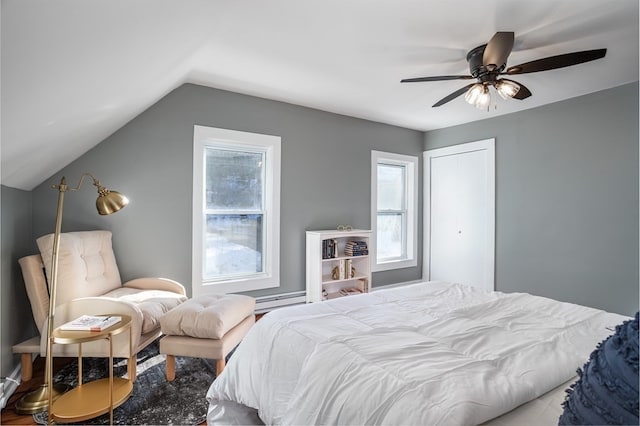 bedroom with lofted ceiling, baseboard heating, ceiling fan, and a closet