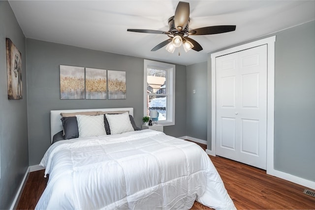 bedroom featuring dark hardwood / wood-style floors, ceiling fan, and a closet