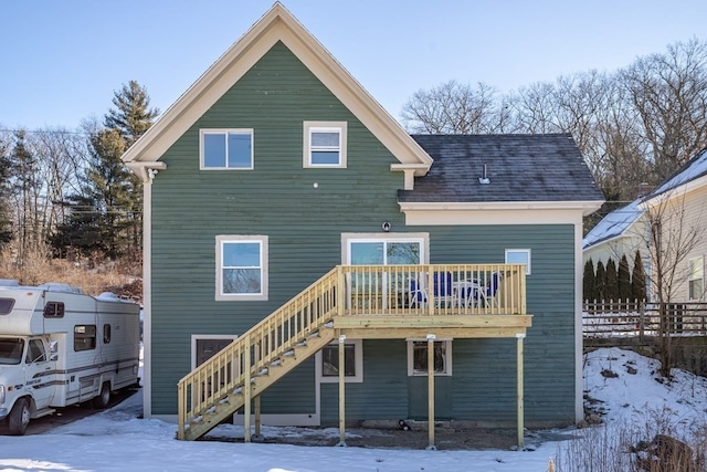 snow covered house featuring a wooden deck