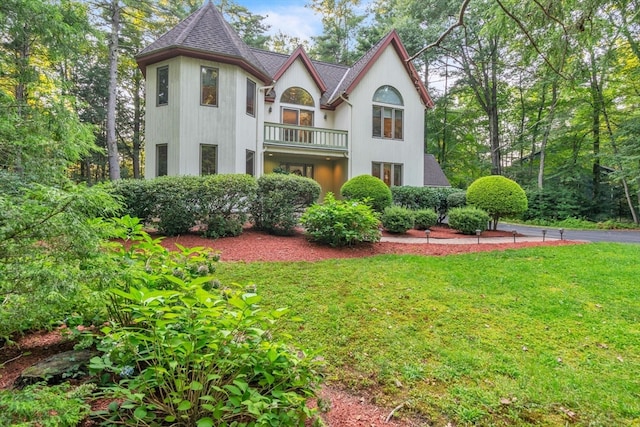 view of front of house featuring a balcony and a front yard