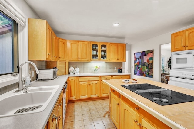 kitchen featuring white appliances, light tile patterned floors, tasteful backsplash, and sink