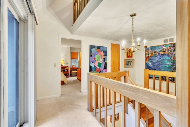 hallway with a notable chandelier and a textured ceiling