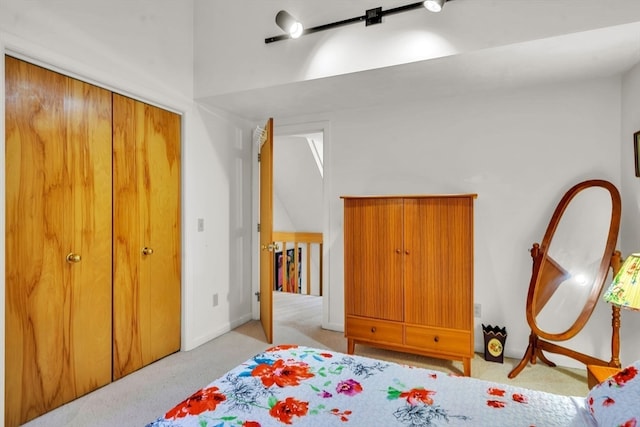 carpeted bedroom with a closet and vaulted ceiling