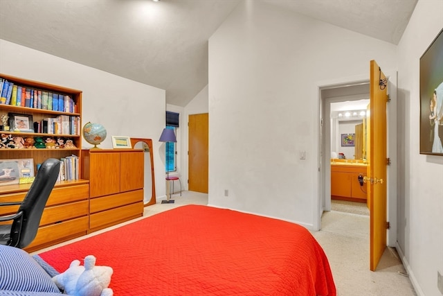 carpeted bedroom featuring lofted ceiling and ensuite bath