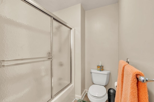 bathroom with shower / bath combination with glass door and toilet