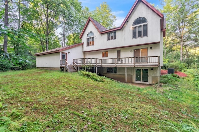 rear view of house featuring cooling unit, a lawn, and a wooden deck