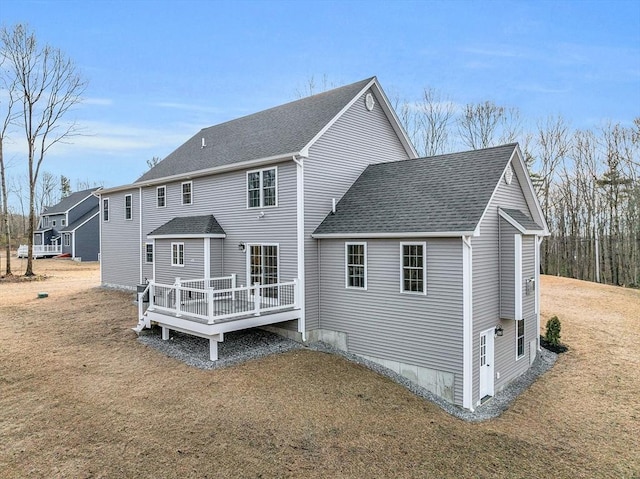 rear view of house with a yard and a deck