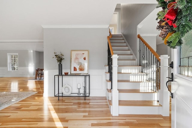 stairs featuring hardwood / wood-style floors and crown molding