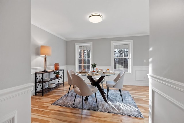 dining space featuring wood-type flooring and ornamental molding