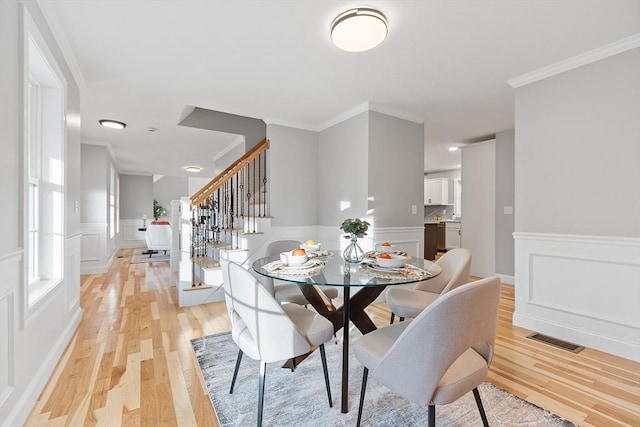 dining room featuring light wood-type flooring and ornamental molding