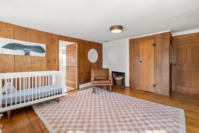 bedroom featuring light hardwood / wood-style flooring and wood walls