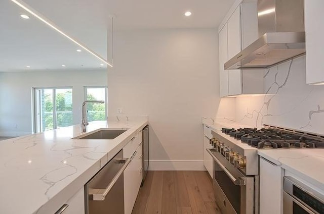 60 Newbury St Unit 10, Quincy, MA 02171 - kitchen with wall chimney range hood, appliances with stainless steel finishes, a sink, recessed lighting, and white cabinets