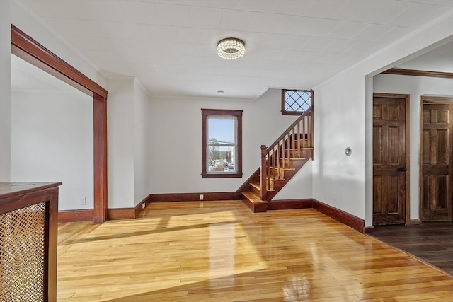 additional living space featuring hardwood / wood-style flooring, baseboards, and stairs