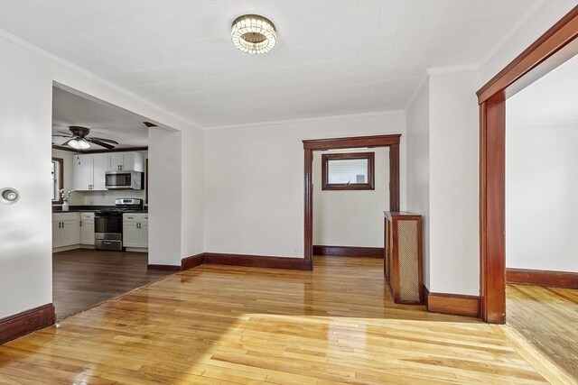 unfurnished dining area featuring baseboards, crown molding, and light wood finished floors