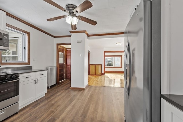 kitchen with gas stove, dark countertops, freestanding refrigerator, and radiator