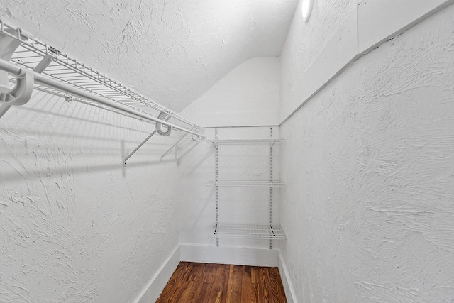 spacious closet with lofted ceiling and wood finished floors