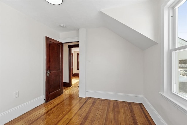 bonus room with lofted ceiling, light wood-style flooring, and baseboards