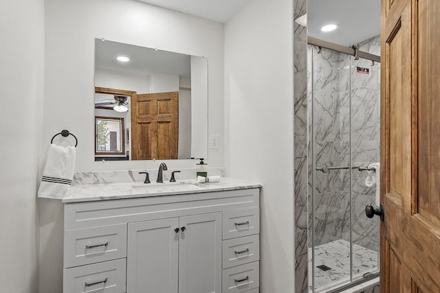 full bath featuring recessed lighting, ceiling fan, vanity, and a marble finish shower