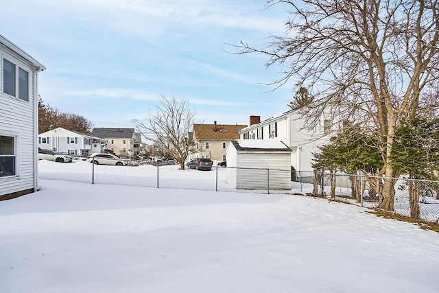 yard covered in snow featuring a residential view and fence