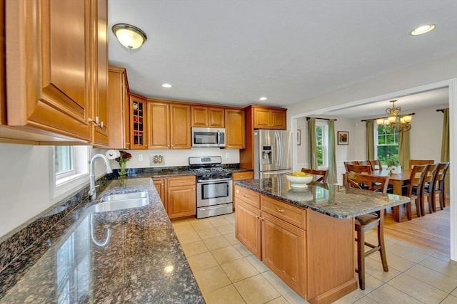 3 White Tail Dr, Tyngsborough, MA 01879 - kitchen featuring appliances with stainless steel finishes, a sink, brown cabinets, a kitchen bar, and light tile patterned floors