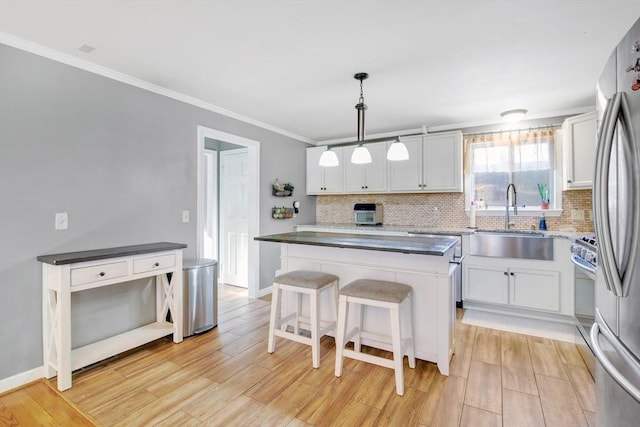 kitchen featuring white cabinetry, sink, pendant lighting, and a center island