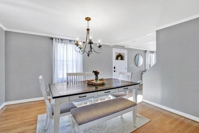 dining room featuring crown molding, light hardwood / wood-style flooring, and a notable chandelier