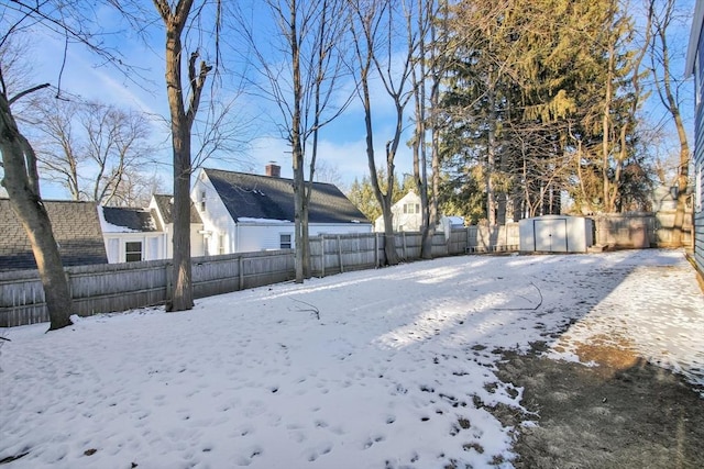 snowy yard with a storage shed