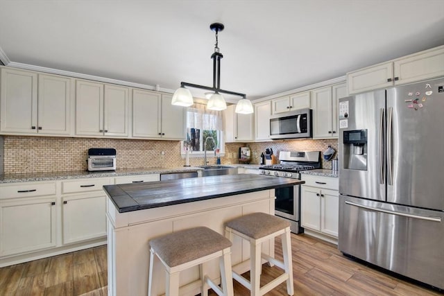 kitchen with backsplash, decorative light fixtures, stainless steel appliances, and a kitchen island