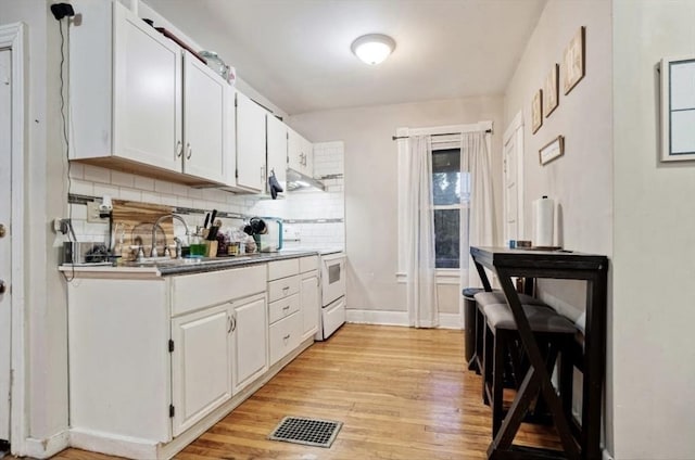 53 Euclid Ave, Springfield, MA 01108 - kitchen featuring white electric range, light wood finished floors, under cabinet range hood, backsplash, and white cabinetry