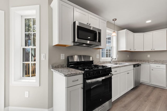 13R Pine Hill Way Unit 13, Harvard, MA 01451 - kitchen with light wood-style flooring, white cabinets, a sink, appliances with stainless steel finishes, and hanging light fixtures