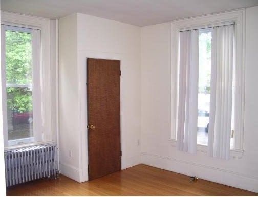 14 Bellevue St, Boston, MA 02125 - spare room with radiator heating unit, wood finished floors, and healthy amount of natural light