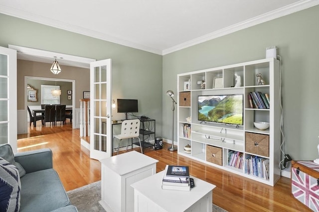 living room featuring french doors, ornamental molding, baseboards, and wood finished floors