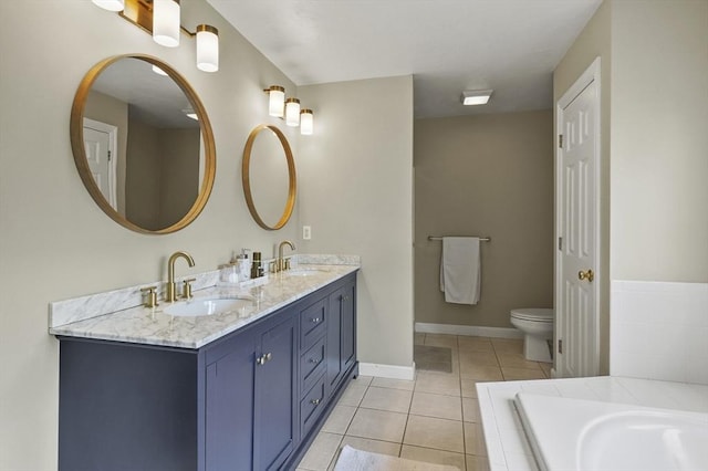 full bath featuring double vanity, toilet, tiled tub, tile patterned floors, and a sink