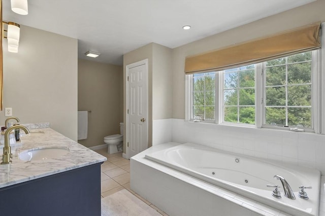 bathroom with a jetted tub, double vanity, tile patterned flooring, a sink, and toilet