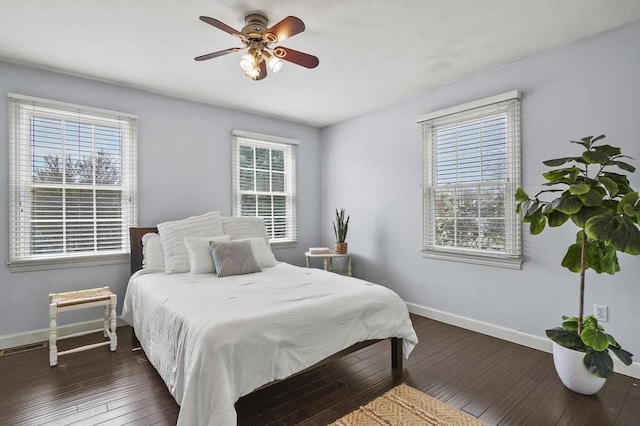 bedroom featuring wood-type flooring, baseboards, and multiple windows