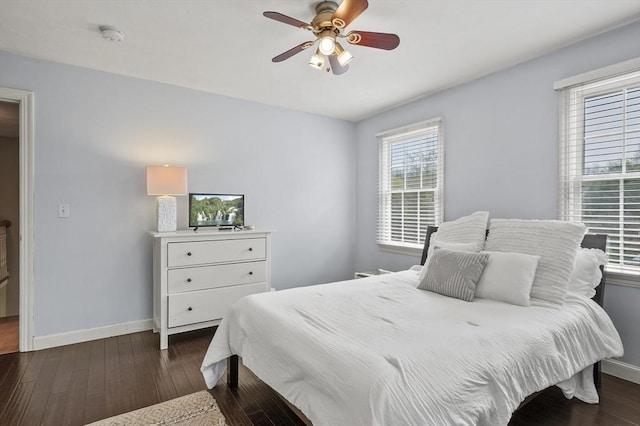 bedroom featuring baseboards, ceiling fan, and dark wood-style flooring