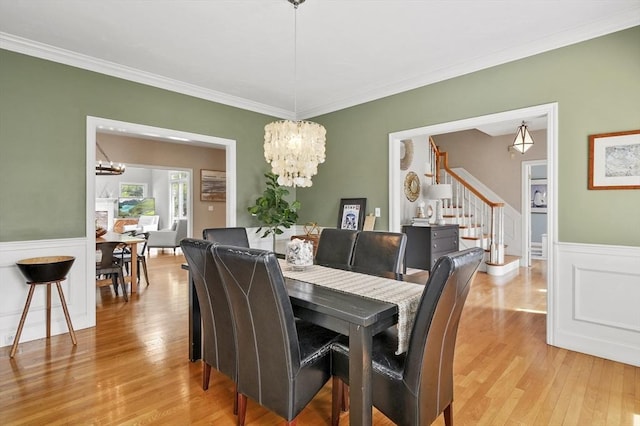dining room with light wood-style floors, stairs, and a chandelier