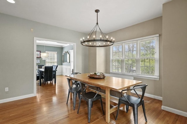 dining area featuring an inviting chandelier, baseboards, and wood finished floors