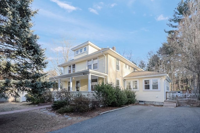 american foursquare style home featuring crawl space, a porch, and a chimney