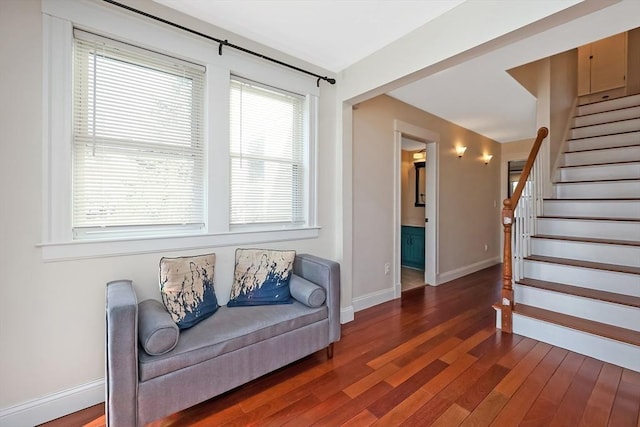 sitting room with baseboards, wood finished floors, and stairs