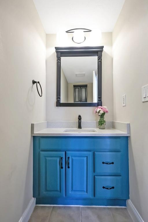 bathroom featuring vanity, baseboards, and tile patterned flooring