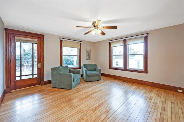 unfurnished room featuring a ceiling fan, light wood-style floors, and baseboards