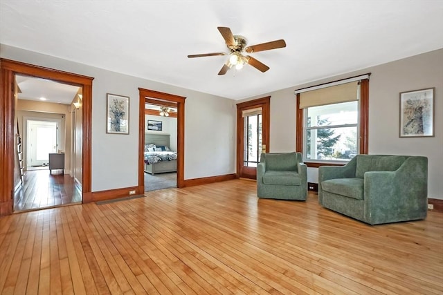 unfurnished room featuring a ceiling fan, baseboards, and light wood finished floors