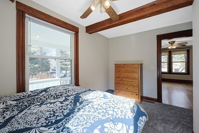 bedroom featuring beamed ceiling, a ceiling fan, baseboards, and carpet floors