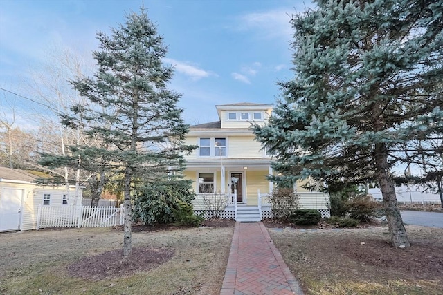 american foursquare style home featuring covered porch and fence