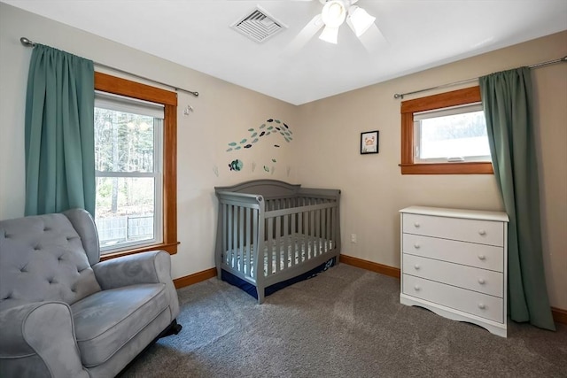 carpeted bedroom with visible vents, multiple windows, and baseboards