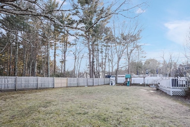 view of yard with a playground, a fenced backyard, and a wooden deck