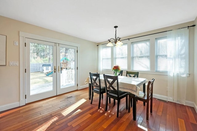 dining area with a wealth of natural light, baseboards, and wood-type flooring