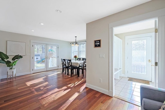 interior space featuring an inviting chandelier, french doors, baseboards, and wood-type flooring