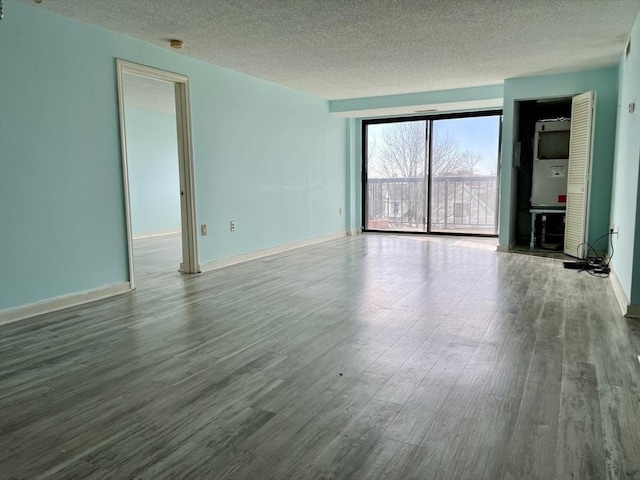 unfurnished room featuring hardwood / wood-style floors and a textured ceiling